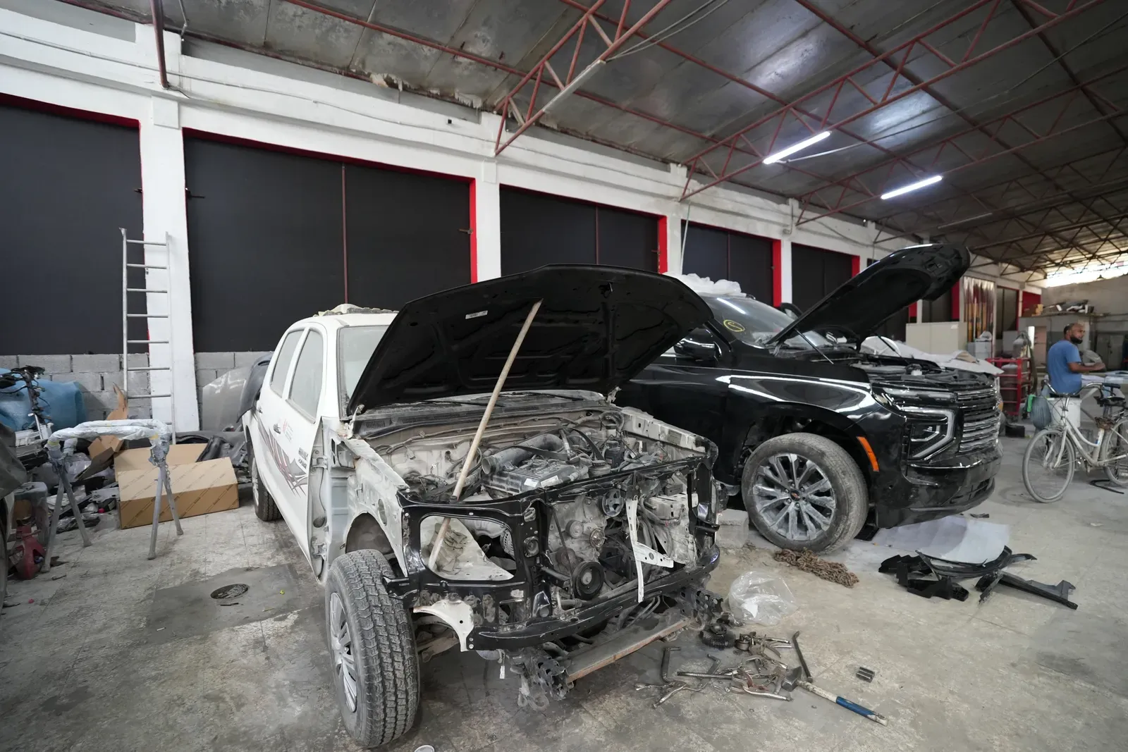 A row of cars with their bonnets open in the body and paint bay in Sharjah.