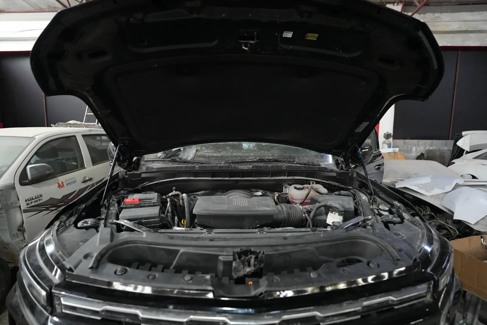 An engine bay open on a vehicle in for work in the workshop.